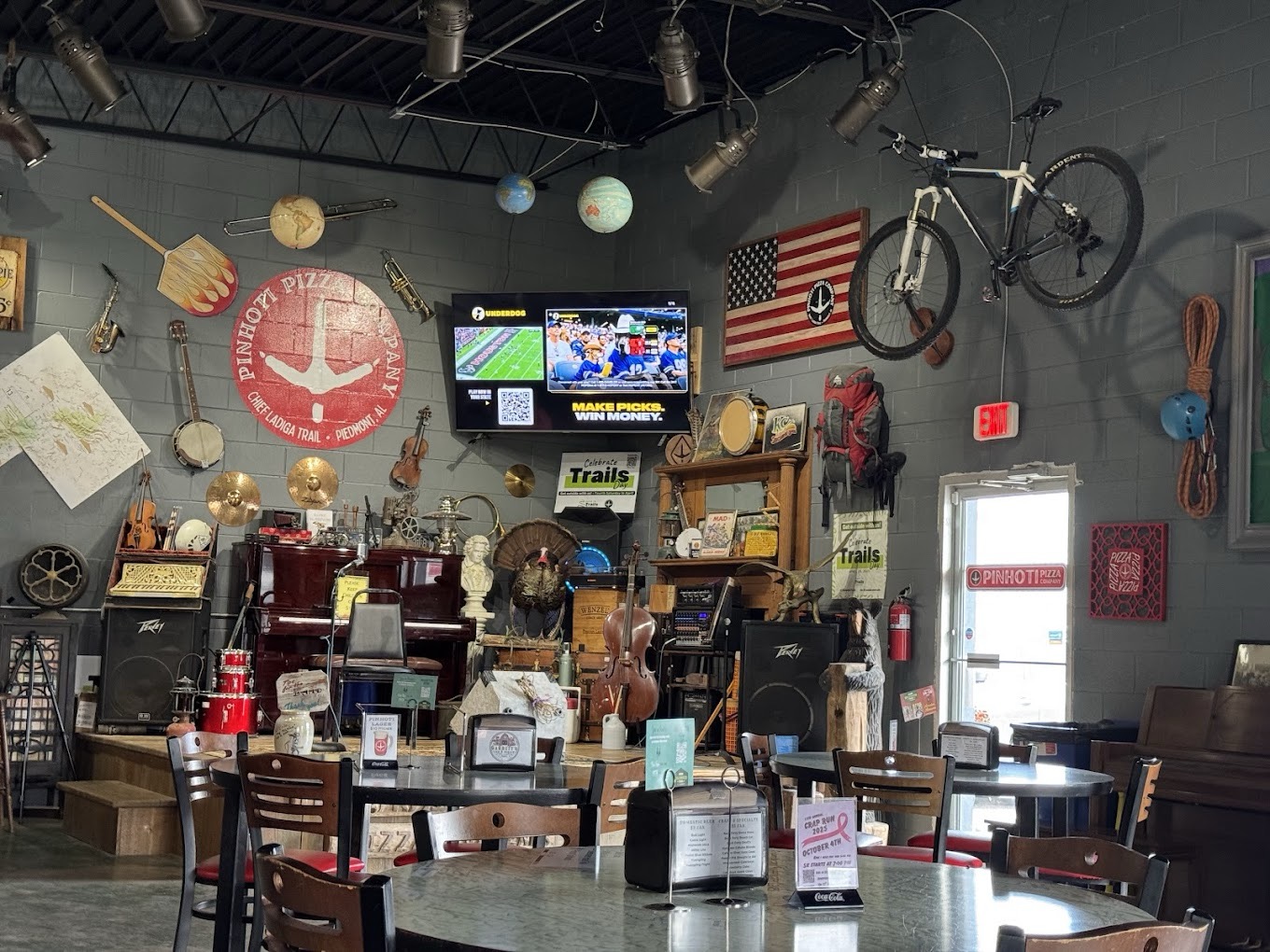 Stage area with instruments and trail-themed decor at Pinhoti Pizza Company
